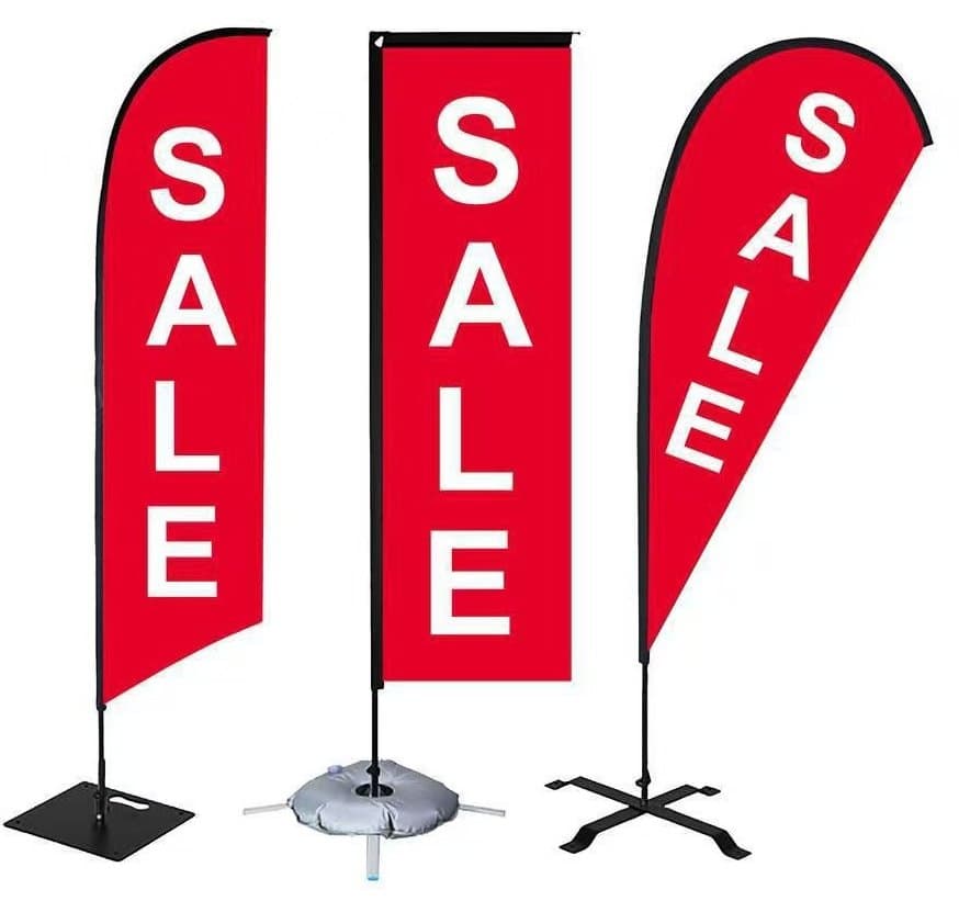 Three red feather beach flags printed with a sale message