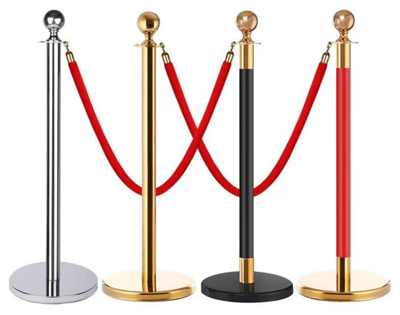 Four rope-and-post barrier stands in chrome, gold and black with red ropes
